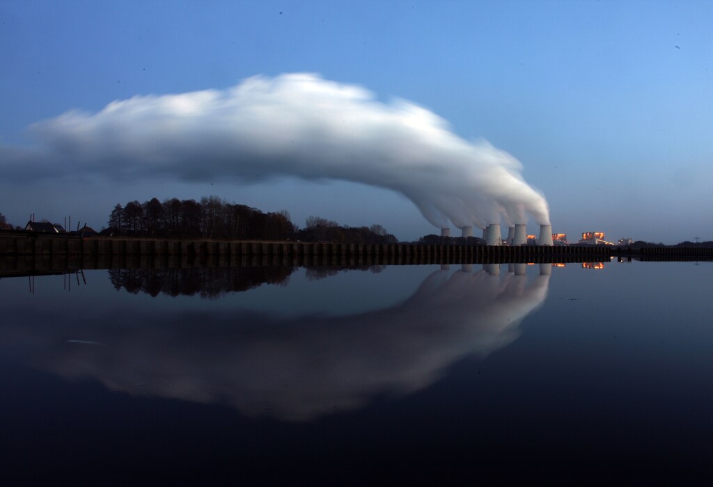 Steam billowing from the cooling towers of Vattenfall's Jaenschwalde brown coal power station is reflected in the water of a lake near Cottbus, eastern Germany December 2, 2009.