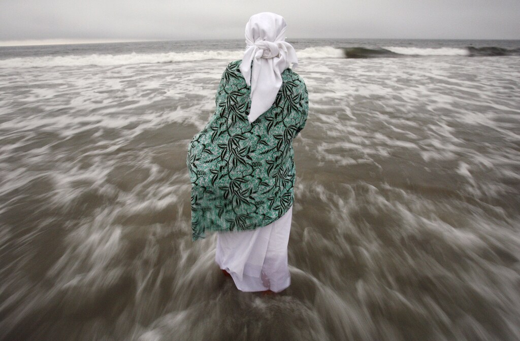 A female parishioner of St. Paul Community Baptist Church stands in the Atlantic Ocean during a Maafa Commemoration in New York September 22, 2007. The Maafa Commemoration honors the millions of Africans lost in the Trans-Atlantic Slave Trade and Middle Passage. REUTERS/Shannon Stapleton (UNITED STATES) - GM1DWFDJWZAA