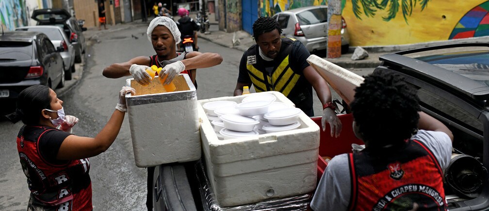 A group of residents of the marginal neighborhood of Chapeu Mangueira, carry boxes of food to give to homeless people in the Copacabana neighborhood during the outbreak of coronavirus disease (COVID-19), in Rio de Janeiro, Brazil, on April 11 2020.