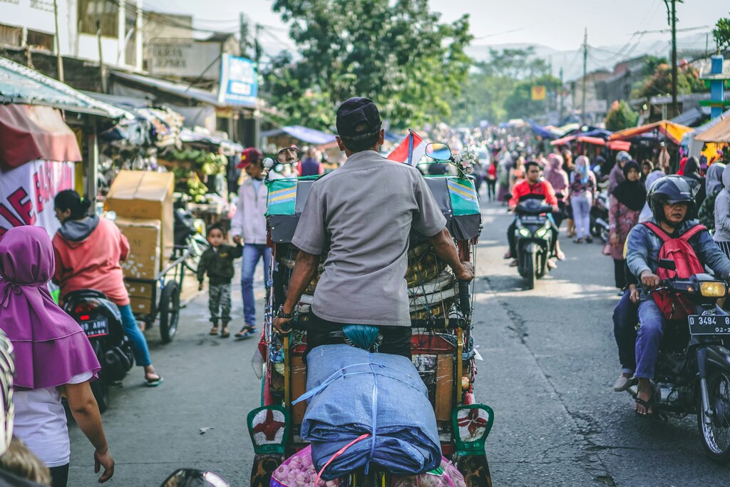 A man pedaling a wagon in Bandung City, Indonesia: Financial inclusion nearly doubled in nine years in Indonesia