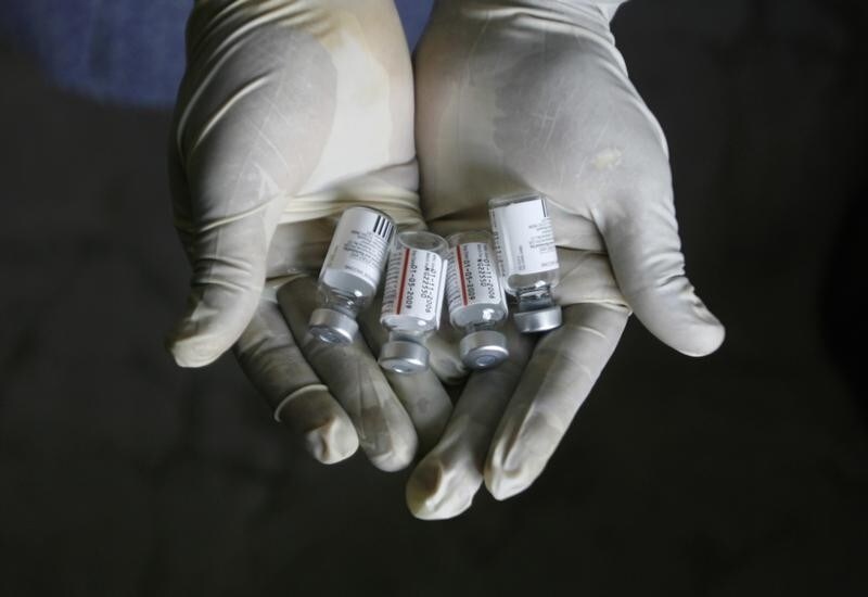 A health worker displays bottles of vaccine 'Pneumovax' during a vaccination programme organised by non-government organisation 'Sngobadho' (Together) at their office on the outskirts of the northeastern Indian city of Siliguri August 5, 2008. India is failing