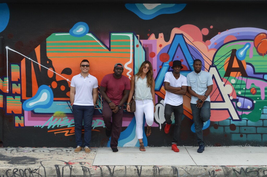 Young people (generation Z) standing against a wall with graffiti.