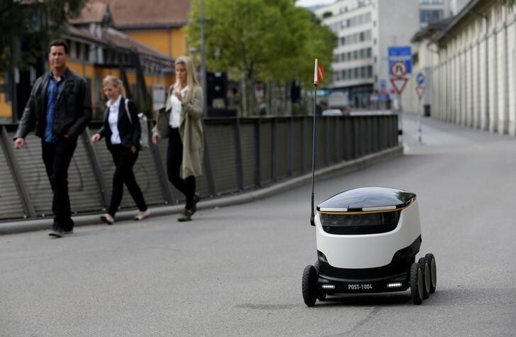 A Swiss Post self-driving delivery robot, capable of carrying up to 10 kg over 1 kilometer, with a speed up to 6 km/h, delivers a package from the department store Jelmoli during a press presentation for the start of the service in Zurich, Switzerland, September 8, 2017. REUTERS/Moritz Hager