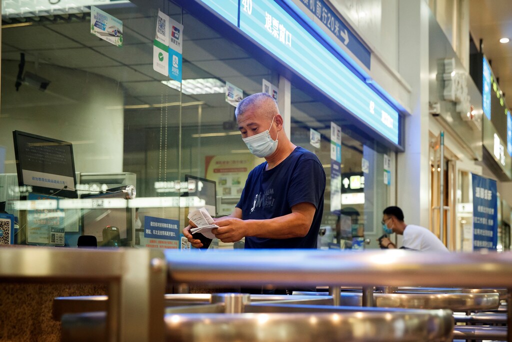 People wear a protective masks as they buy tickets at the Beijing South Railway Station, after an outbreak of the coronavirus disease (COVID-19), in Beijing, China July 3, 2020.