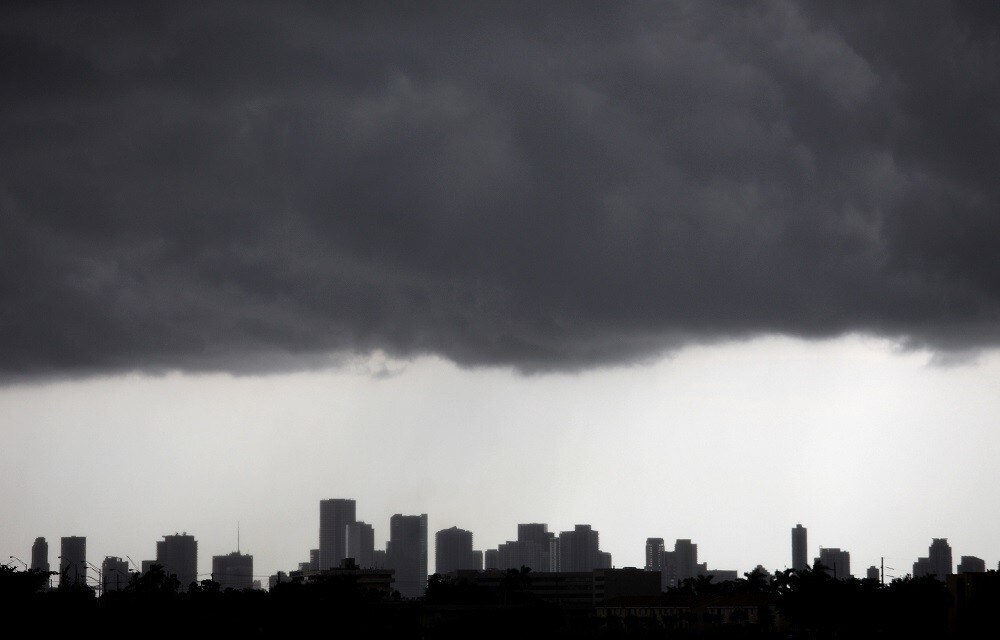 Dark clouds pass over downtown Miami, Florida August 15, 2010. An area of low pressure over southwest Georgia could move southward into Gulf of Mexico waters by early Monday and has a medium chance of becoming a tropical cyclone in the next 48 hours, the National Hurricane Center said on Sunday. The low pressure area was the remnant of Tropical Depression Five which dissipated on Wednesday in the Gulf. The U.S. Gulf of Mexico is home to about 30 percent of U.S. oil production, 11 percent of natural gas production, and more than 43 percent of U.S. refinery capacity. REUTERS/Carlos Barria