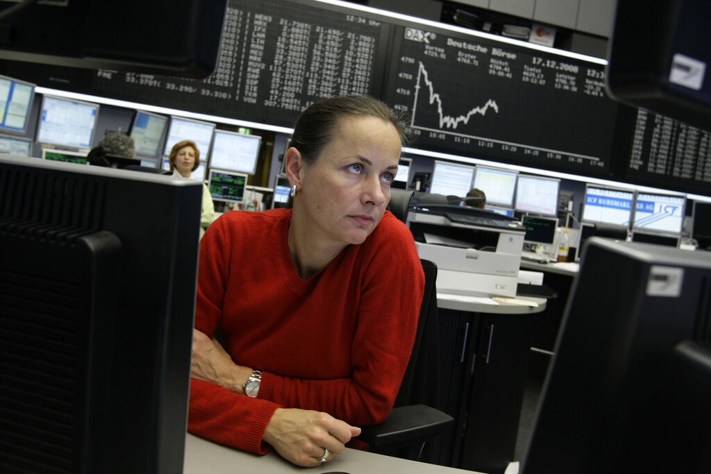 A trader watches her screens in front of the main board showing the DAX curve at the Frankfurt stock exchange December 17, 2008. European shares fell in early trade on Wednesday as investors shrugged off a Federal Reserve rate cut and focused instead on worries about more banking sector losses. REUTERS/Alex Grimm (GERMANY) - RTR22NM8