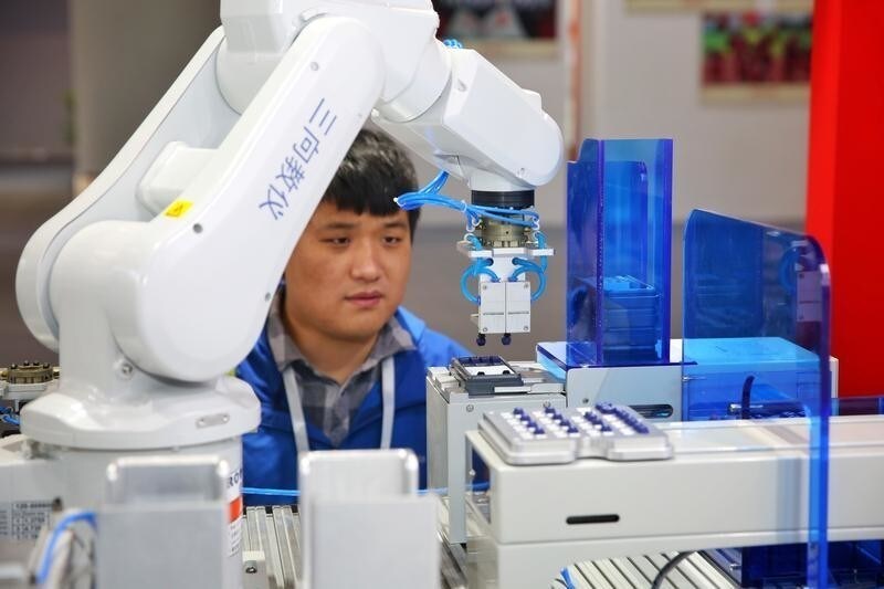 A robotic arm assembles an electronic calculator at the Convention on the Exchange of Overseas Talents in Guangzhou, Guangdong province, China December 20, 2017. Picture taken December 20, 2017. REUTERS/Stringer ATTENTION EDITORS - THIS IMAGE WAS PROVIDED BY A THIRD PARTY. CHINA OUT. - RC198CEEDAB0