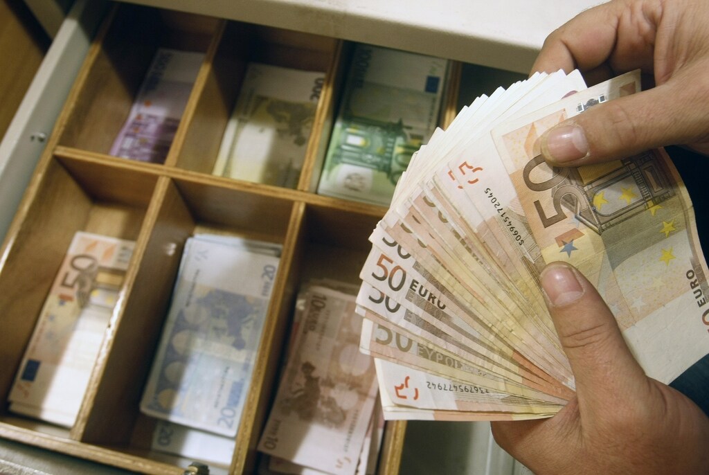 A teller counts euro banknotes inside a National Bank of Greece branch in Athens February 10, 2010. Euro zone countries held intensive talks on Wednesday on a possible rescue for Greece, whose debt crisis has shaken the entire currency union, as civil servants staged the first big strike against Athens' austerity plans. Financial markets gave Greece some respite as investors hoped that other European governments would help Athens to head off a possible default on its debt repayments. REUTERS/John Kolesidis (GREECE - Tags: BUSINESS POLITICS IMAGES OF THE DAY) - RTR2A1JP