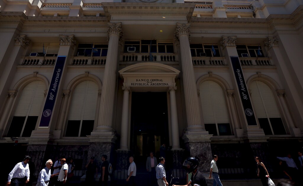 People walk past Argentina's Central Bank in Buenos Aires' financial district, Argentina, December 16, 2015. Argentina will announce a much anticipated relaxation of currency controls on Wednesday, the government said, setting the stage for a weakening of the local peso and an increase of soybean shipments from the world's No. 3 exporter. REUTERS/Marcos Brindicci