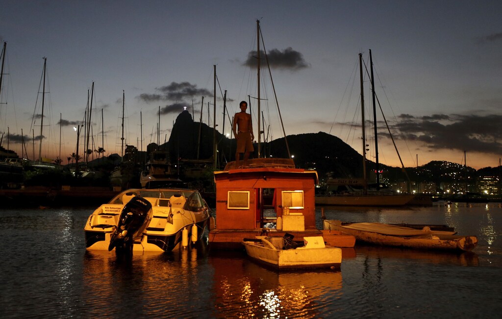 Naval carpenter Alexandro de Oliveira, 41, stands atop his boat house in the waters of the Guanabara Bay in Rio de Janeiro Brazil, April 5, 2016.