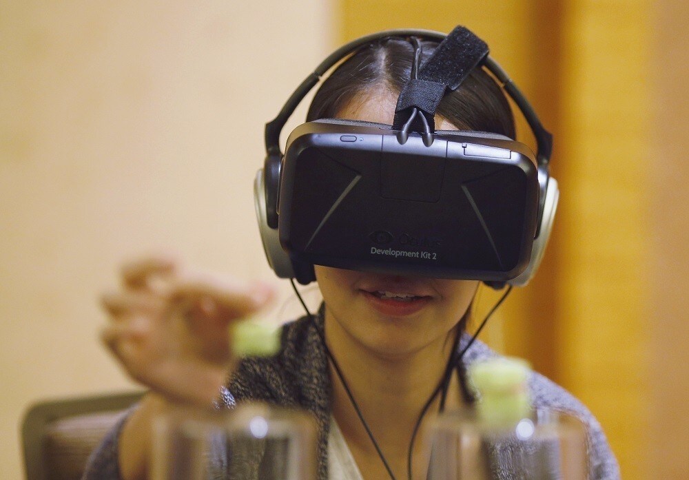 A visitor tastes food using Tasteworks technology, a Virtual Reality experience created by Dan Garrett and Alex Kitching of the Royal College of Art and Imperial College London that augments and stimulates taste, during a design competition showcase of wearable technology at the Augmented Human International Conference in Singapore March 10, 2015. The conference runs from March 9 to 11. Tasteworks was developed from a study of dementia patients' communication difficulties. Such patients with deteriorating recognition capabilities may find eating stressful and unenjoyable. Using Oculus Rift and Leap Motion technology, Tasteworks places the subject in a "hyper realistic Virtual World" where flavour can be generated and emphasized. REUTERS/Edgar Su