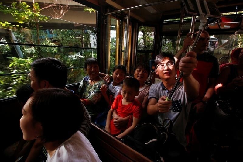A mainland Chinese tourist takes a selfie inside a Peak Tram in Hong Kong, China August 4, 2017. REUTERS/Bobby Yip - RC13BD7D0BD0