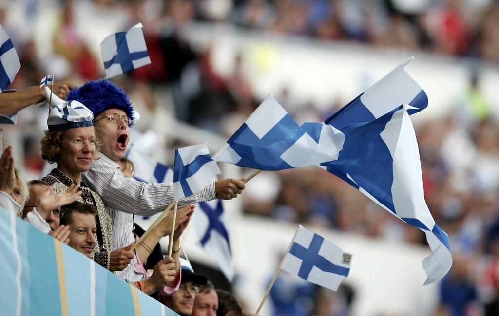 Spectators cheer and wave Finnish flags during the eighth day of competition at the world athletics championships in Helsinki August 13, 2005. REUTERS/Dylan Martinez AA/mk - RP6DRMRPVVAA