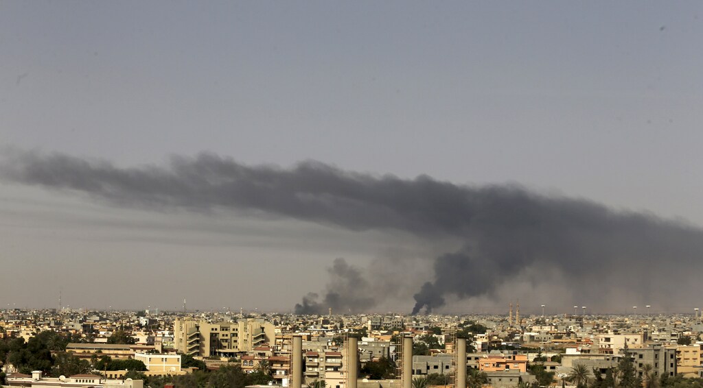 Black plumes of smoke is seen in the vicinity of Camp Thunderbolt, after clashes between militants, former rebel fighters and government forces in Benghazi July 27, 2014. At least 36 people were killed in Libya's eastern city of Benghazi, many of them civilian, where Libyan Special Forces and Islamist militants clashed on Saturday night and Sunday morning, medical and security sources said. REUTERS/Esam Omran Al-Fetori (LIBYA - Tags: CIVIL UNREST POLITICS) - RTR40AMG