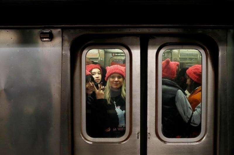 A group of people wearing "pussyhats" ride the subway at 42nd Street as they head toward the Women's March in Manhattan, New York City, New York, U.S., January 20, 2018. REUTERS/Andrew Kelly TPX IMAGES OF THE DAY - RC157BC958D0