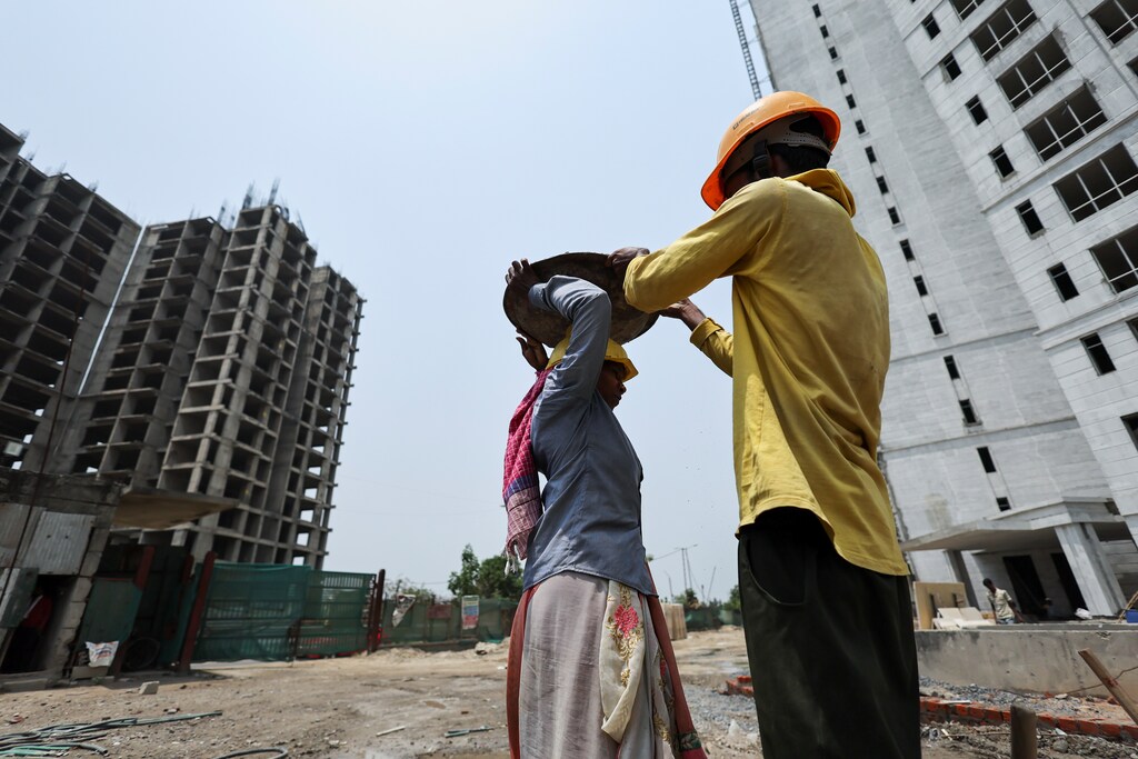 Labourers work at a construction site on a hot summer day in Noida, India, May 12, 2022. Infrastructure growth in developing countries will lead to increased demand for steel and cement by a projected 30% and 45%, respectively, by 2050. That means decarbonization is a major challenge.