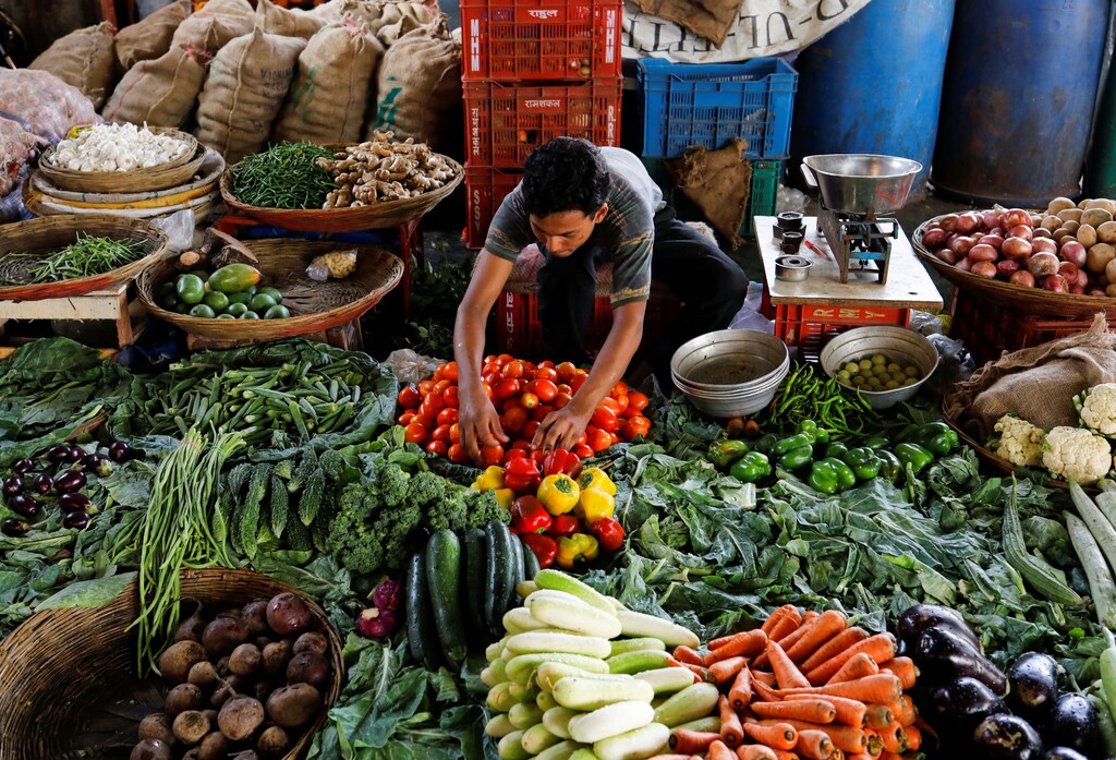 A vendor sorts tomatoes as he waits for customers at a vegetable market in Mumbai, India, June 12, 2018. REUTERS/Danish Siddiqui - RC1D3D31C750