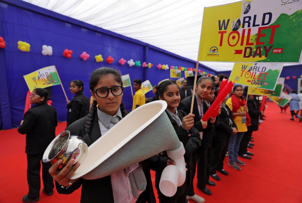 A school girl holds a replica of a toilet pot during an event to mark World Toilet Day in New Delhi, India, November 19, 2018. REUTERS/Anushree Fadnavis - RC17249D0200