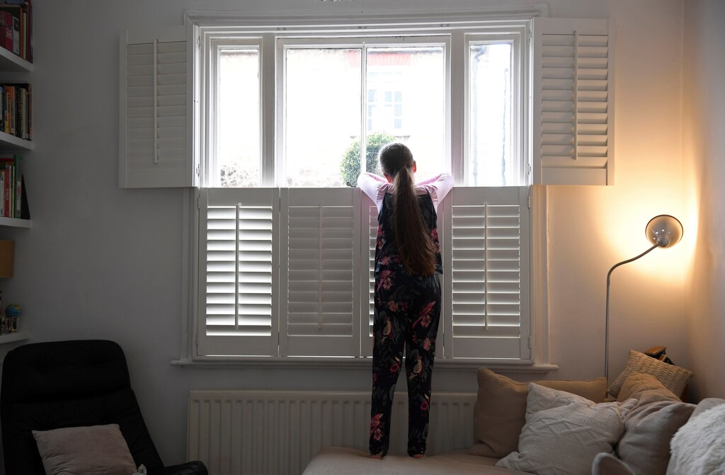 Nine-year-old Eve looks out of the front window at home, as the number of coronavirus disease (COVID-19) cases grow around the world, in London, Britain, March 17, 2020. REUTERS/Toby Melville - women men female male girls boys teenagers teens development gender gap parity equality diversity progress change feminine masculine woman man sex biology roles dynamic balance bias androgynous Coronavirus china virus health healthcare who world health organization disease deaths pandemic epidemic worries concerns Health virus contagious contagion viruses diseases disease lab laboratory doctor health dr nurse medical medicine drugs vaccines vaccinations inoculations technology testing test medicinal biotechnology biotech biology chemistry physics microscope research influenza flu cold common cold bug risk symptomes respiratory china iran italy europe asia america south america north washing hands wash hands coughs sneezes spread spreading precaution precautions health warning covid 19 cov SARS 2019ncov wuhan sarscow wuhanpneumonia pneumonia outbreak patients unhealthy fatality mortality elderly old elder age serious death deathly deadly