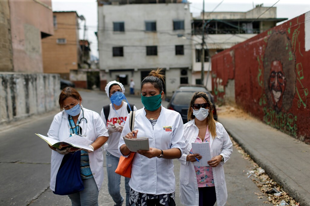 A team consisting of Cuban and Venezuelan healthcare workers walk during an inspection round at the slum of Lidice during the nationwide quarantine due to the coronavirus disease (COVID-19) outbreak in Caracas, Venezuela April 9, 2020.