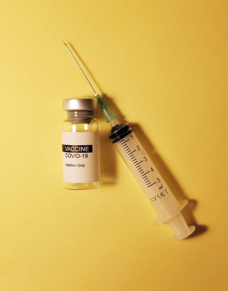 covid-19 vaccine stock photo with a vial and syringe.