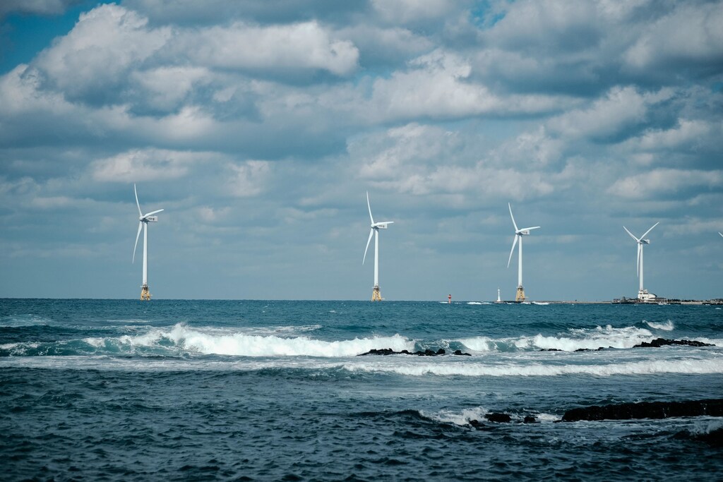 The sea with wind turbines in the background.