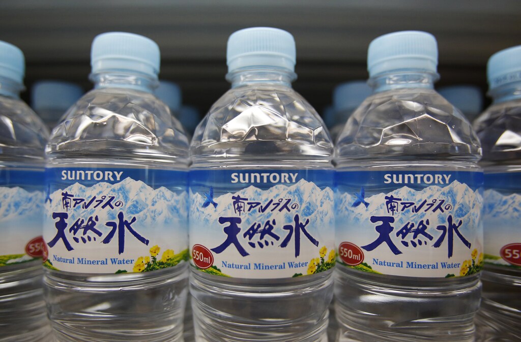 Suntory logos are seen on the labels of Suntory Beverage & Food Ltd.'s plastic bottled water displayed at a store in Tokyo February 17, 2014. The head of Suntory Holdings Ltd said on Monday the $13.6 billion takeover of U.S. whiskey maker Beam Inc would help the Japanese spirits maker expand in emerging markets Brazil, Russia, India and China.