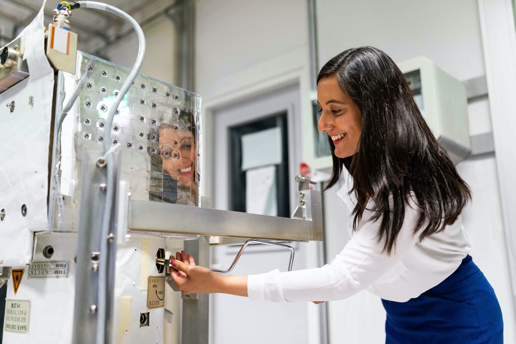 a female space operations engineer maintaining equipment