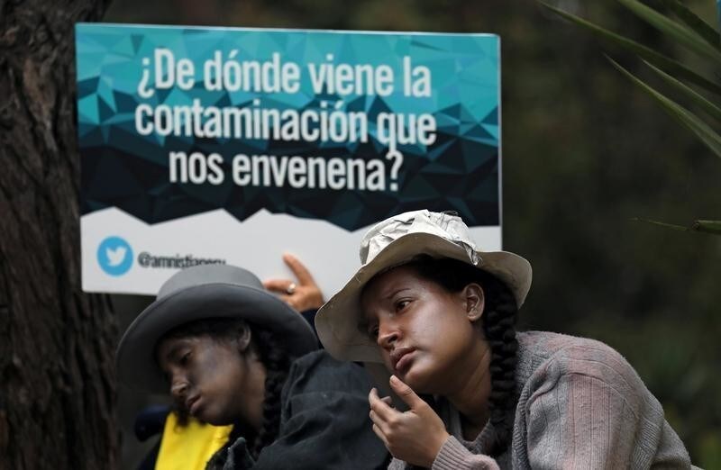 Supporters of communities affected by toxic metals perform during a protest in front of the Health Ministry in Lima, Peru July18, 2018. The sign reads: "Where does the pollution that poisons us come from?" REUTERS/Mariana Bazo - RC1A87003460