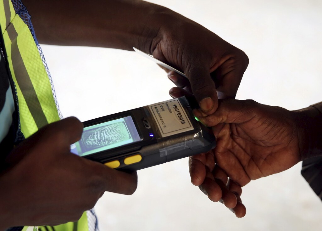 An electoral commission worker takes a fingerprint of a voter in a polling station during elections in Kano March 28, 2015. Nigerians voted on Saturday in what looks set to be the first genuine electoral contest since the end of military rule in 1999, one in which an opposition aspirant has a fighting chance of unseating the incumbent, President Goodluck Jonathan. REUTERS/Goran Tomasevic - GF10000041405