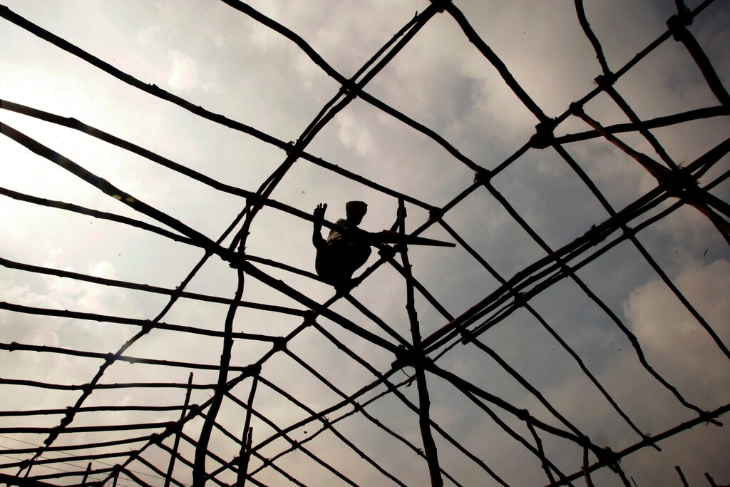 A worker prepares a roof for a shelter for tsunami victims at a fishing hamlet in Panavalan Kudi, in the southern Tamil Nadu state, January 9, 2005. At least 156,000 people were killed across Asia by the Dec. 26 earthquake and subsequent tsunami, the most widespread natural disaster in living memory. Well over 100,000 are missing, and there is little hope of finding many of them alive. NO RIGHTS CLEARANCES OR PERMISSIONS ARE REQUIRED FOR THIS IMAGE. REUTERS/Kamal Kishore KK/FA - RP5DRIEXUTAA