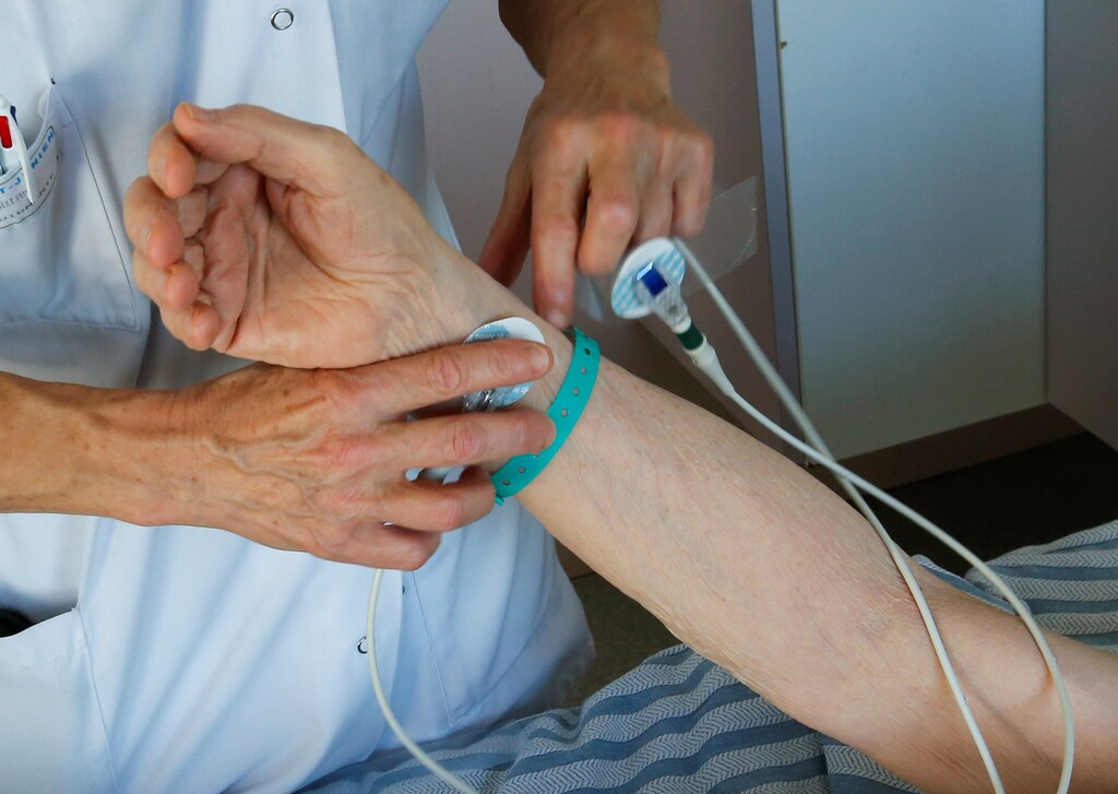 A nurse prepares a patient for an electrocardiogram.