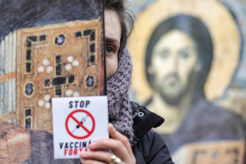 A woman holding an Orthodox religious icon depicting Jesus Christ and a sticker reading "Stop mandatory vaccinations" attends a protest against mandatory mask wearing and coronavirus disease (COVID-19) vaccination, in Bucharest, Romania March 20, 2021. Inquam Photos/Octav Ganea via REUTERS ATTENTION EDITORS - THIS IMAGE WAS PROVIDED BY A THIRD PARTY. ROMANIA OUT. NO COMMERCIAL OR EDITORIAL SALES IN ROMANIA