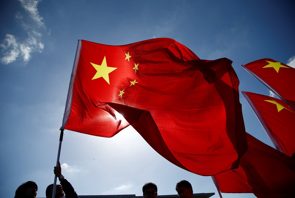 People wave with flags before the a meeting of Chinese Premier Li Keqiang and German Chancellor Angela Merkel at the Chancellery in Berlin, Germany, June 1, 2017. REUTERS/Fabrizio Bensch - RTX38HHY