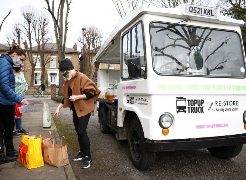 Ella Shone, serves a customer from her mobile zero waste shop called the 'Top Up Truck'. Using a repurposed electric milk float, Ella delivers packaging free products such as cooking oil, shampoo and grains to peoples homes, allowing them to fill up their own containers with the produce, in London, Britain, February 19, 2021.