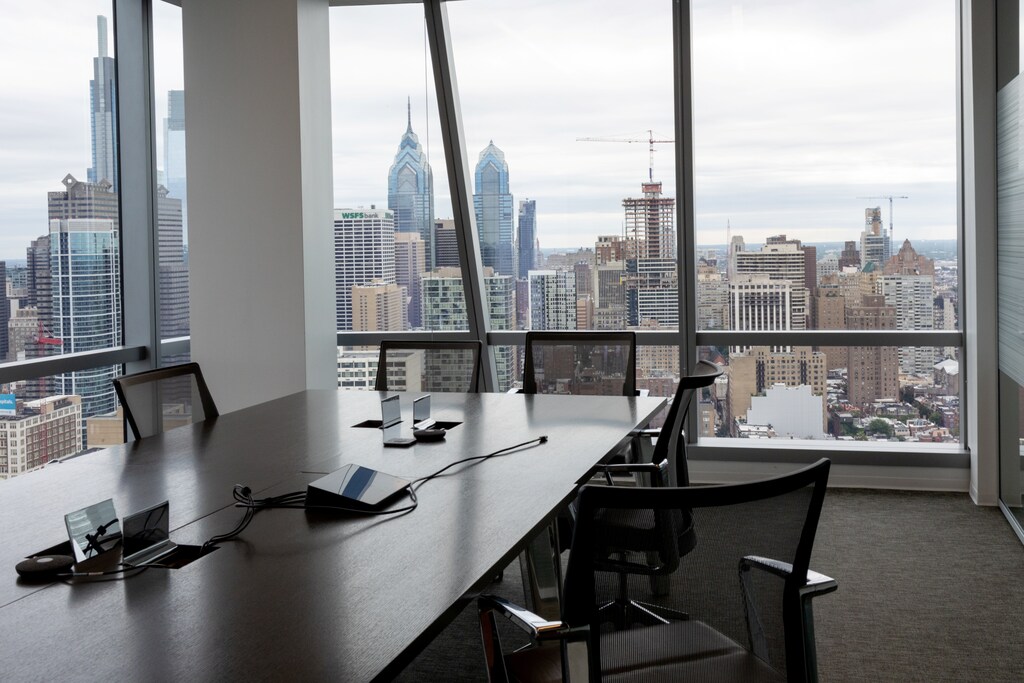 An empty conference room is seen against a city sky drop representing the switch to remote working by many companies