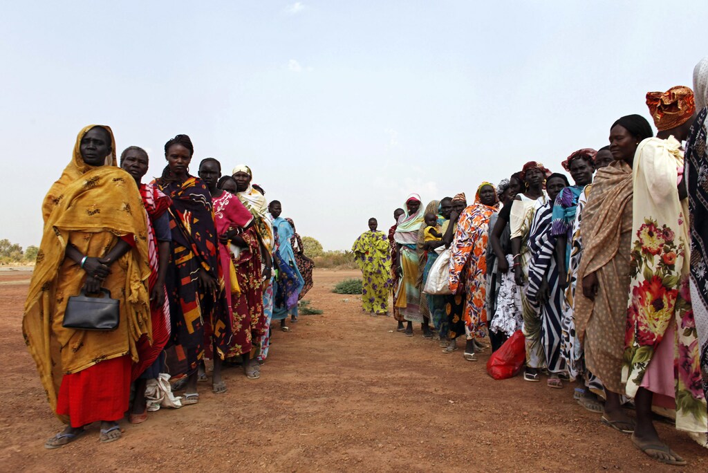 Returnees from north Sudan wait in line for World Food Program (WFP) staff to start distributing food in Aweil in the northern Bahr el Ghazal state in south Sudan December 29, 2010. People from Sudan's oil-producing south are widely expected to vote to split away to form Africa's newest nation in a referendum scheduled to take place on January 9, 2011 that was promised in a 2005 peace deal ending a civil war between north and south. REUTERS/Goran Tomasevic (SUDAN - Tags: POLITICS IMAGES OF THE DAY) - RTXW2UI