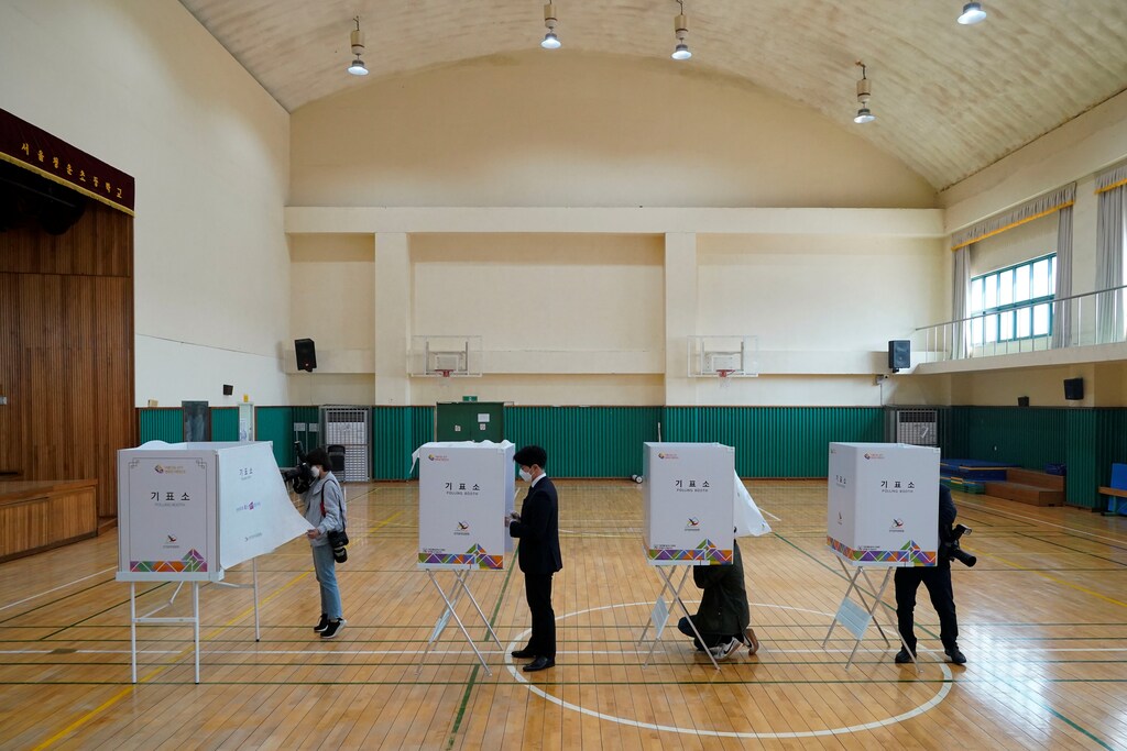 Media members cover inside a polling station for upcoming parliamentary election in Seoul, South Korea, April 14, 2020. REUTERS/Kim Hong-Ji - RC254G97KGMX