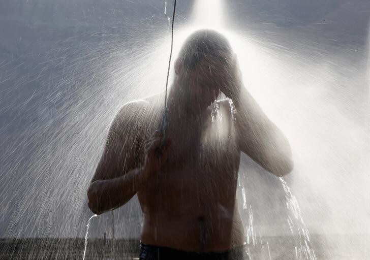 A man takes a shower on the shore of the Dead Sea, near the West Bank Jewish settlement of Mitzpe Shalem, December 1, 2012. REUTERS/Marko Djurica (ISRAEL - Tags: ENVIRONMENT TRAVEL)