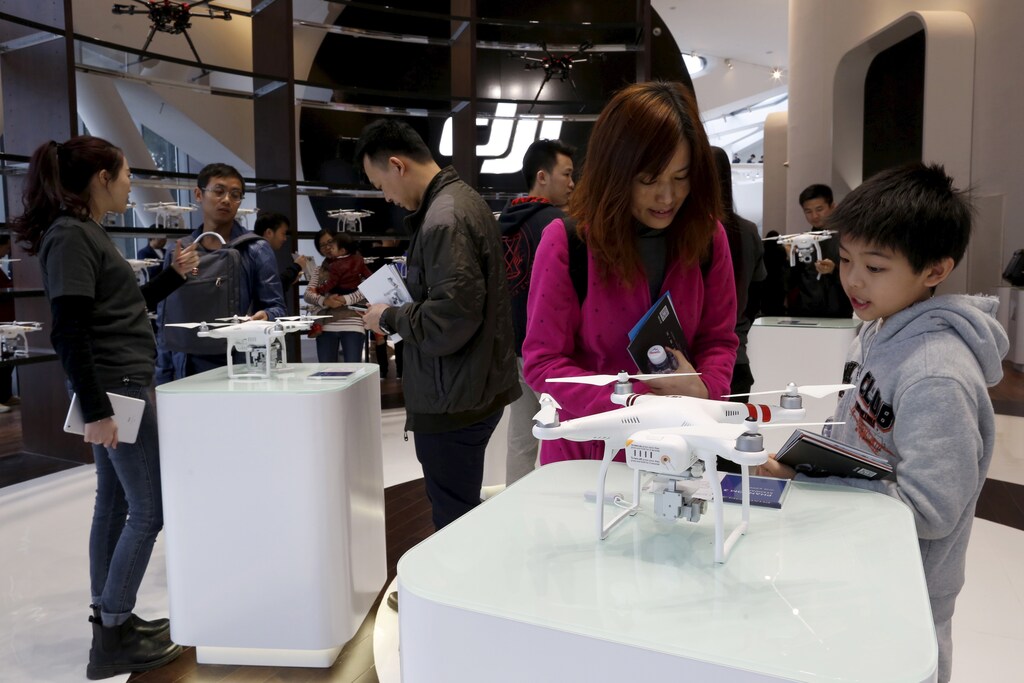 Customers look at a DJI's Phantom 3 drone at their first flagship store in Shenzhen, Guangdong province, China December 20, 2015.