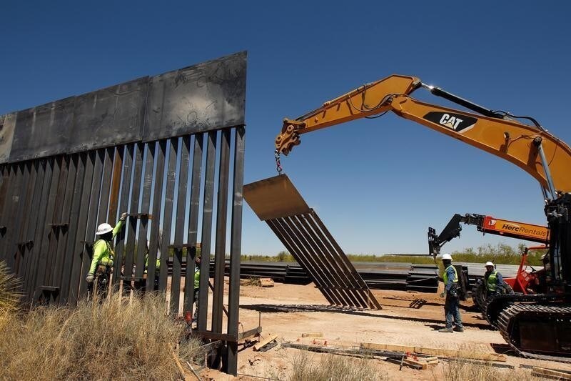 Construction workers are seen next to heavy machinery while working on new bollard wall in Santa Teresa, New Mexico, as seen from the Mexican side of the border in San Jeronimo, on the outskirts of Ciudad Juarez, Mexico April 23, 2018.