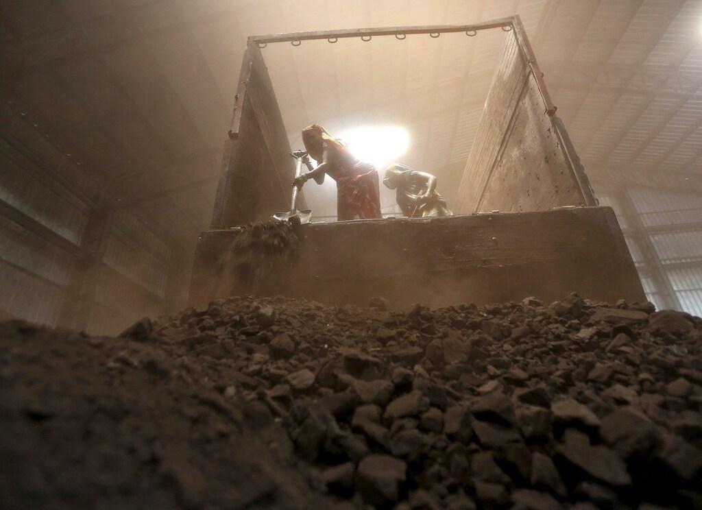Workers unload coal from a supply truck at a yard on the outskirts of the western Indian city of Ahmedabad April 15, 2015. Fewer power cuts are likely in India this summer after a surge in output at Coal India helped generators amass record stocks, a turnaround for Narendra Modi who had to battle a power crisis within months of becoming prime minister last May. Fast-track mine approvals, tighter production oversight and more flexibility in coal sales have helped power station stocks recover from a six-year low hit in October, vindicating Modi's pitch to voters as the state leader who brought round-the-clock power to industrial Gujarat.