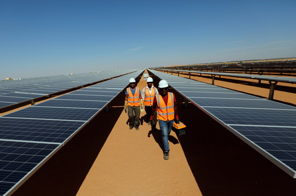Workers walk between photovoltaic panels at the Benban plant in Aswan, Egypt, November 17, 2019. Picture taken November 17, 2019. REUTERS/Amr Abdallah Dalsh - RC24XD9HVF1F