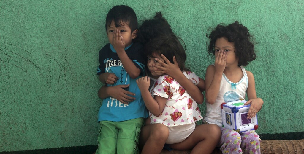 Children cover their faces outside their house while a health ministry worker fumigates to kill mosquitoes during a campaign against dengue and chikungunya and to prevent the entry of Zika virus in Managua, Nicaragua January 28, 2016.