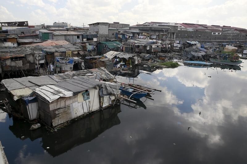 Shanties are built by residents over a polluted river in Navotas city, north of Manila February 23, 2016. The World Bank on Saturday approved $450 million of funding for the Philippines' flagship anti-poverty program, which will provide basic healthcare and education to millions of families until 2019. REUTERS/Romeo Ranoco - GF10000319919