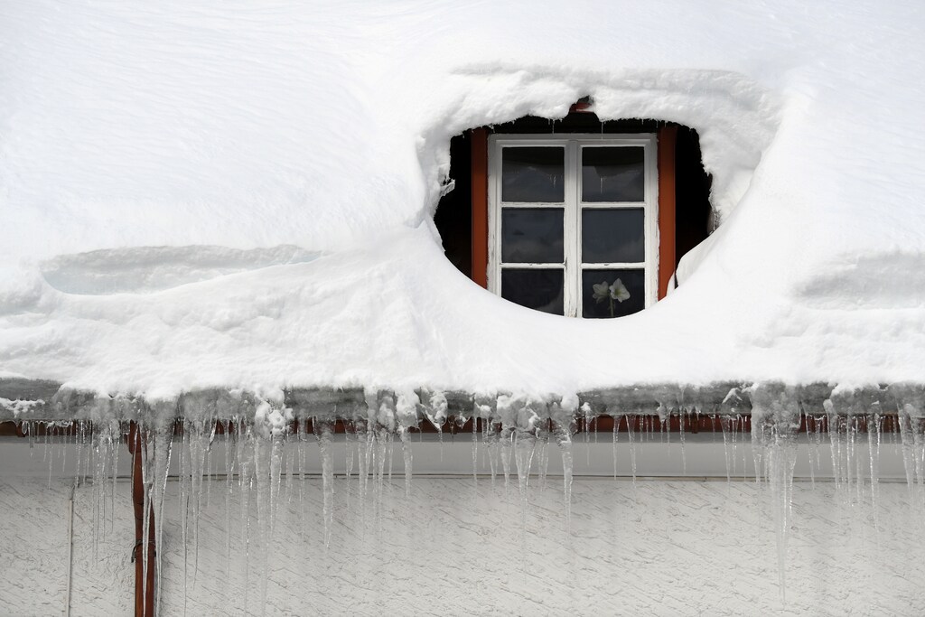 Icicles hang from a rain gutter on a house that is covered with snow in Oberjoch, Germany, January 15, 2019. REUTERS/Andreas Gebert - RC17CCC15F40