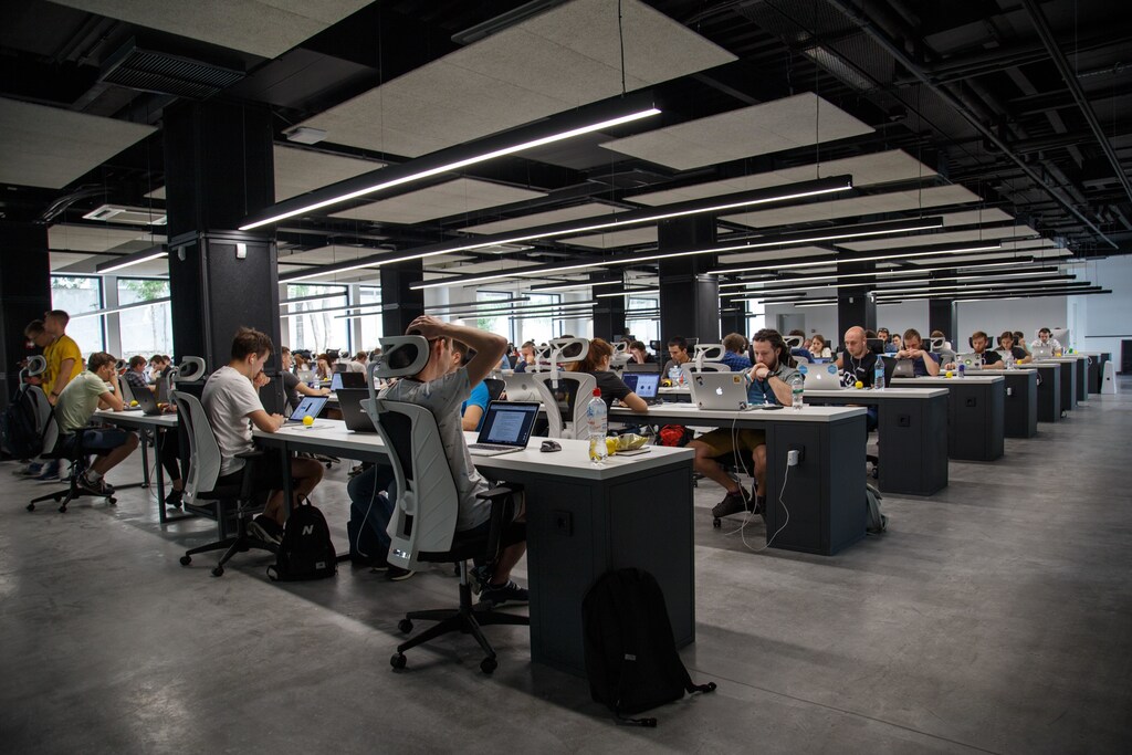 What will the future of work look like if it embraces four day work week? (Pictured here: Workers on computers sitting in an open plan office.)