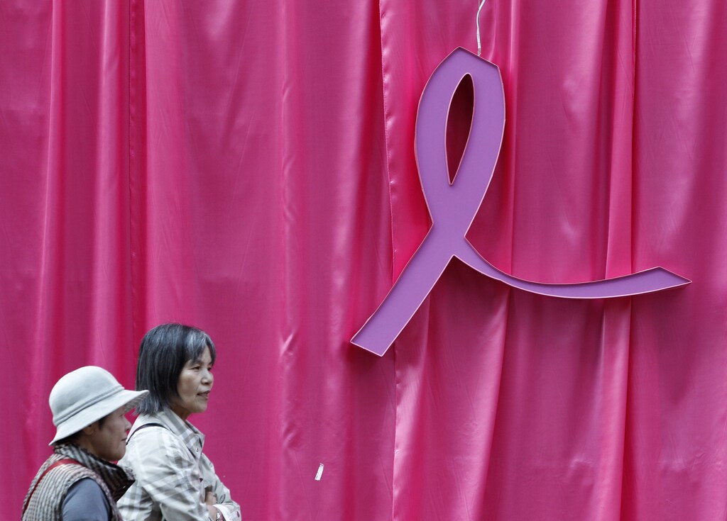 Visitors walk past a sculpture of a pink ribbon installed to promote the "Pink Ribbon" breast cancer awareness campaign at Cheonggye Stream in central Seoul October 5, 2011. The annual campaign is held to promote awareness of breast cancer and to support the fight against it. REUTERS/Jo Yong-Hak (SOUTH KOREA - Tags: HEALTH SOCIETY) - GM1E7A51CA201