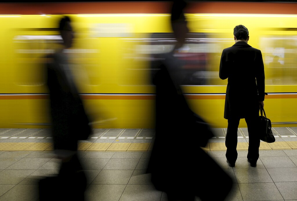 A man looks at his mobile phone as he waits for a subway at a station at a business district in Tokyo, Japan, February 19, 2016. Confidence at Japanese manufacturers remained largely subdued in February and the mood was seen deteriorating over the coming three months, a Reuters poll showed, highlighting concerns about slowing global growth and turbulent markets. REUTERS/Yuya Shino TPX IMAGES OF THE DAY - GF10000314709