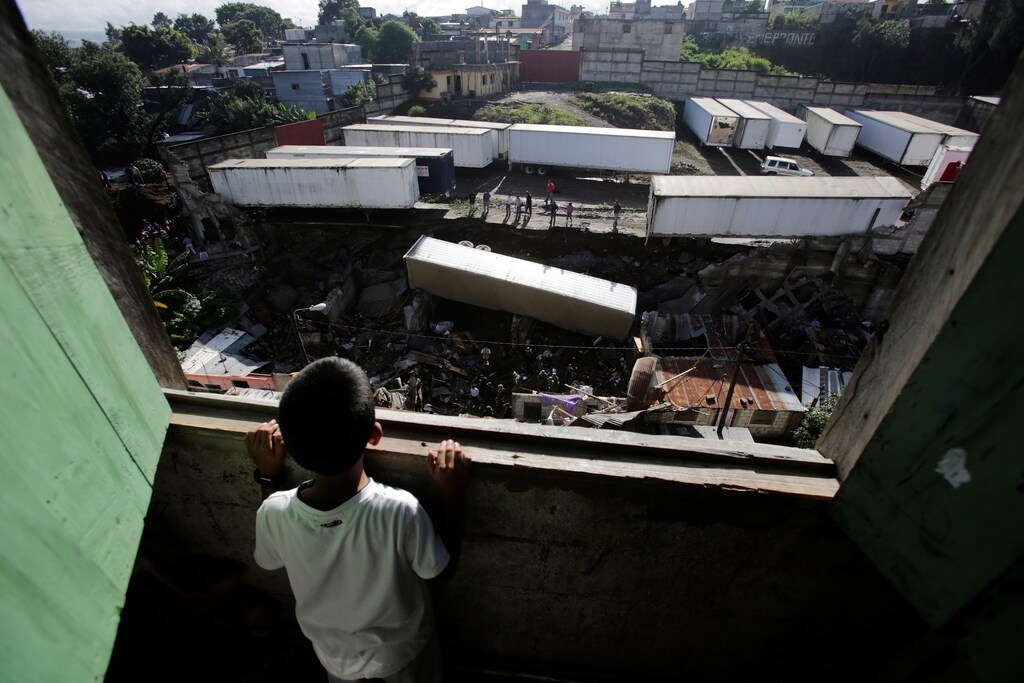 A child looks at the site where a landslide took place causing a trailer to fall on top of homes causing several casualties in Villanueva, on the outskirts of Guatemala City, Guatemala, September 7, 2016. REUTERS/Saul Martinez TPX IMAGES OF THE DAY - RTX2OJ1I